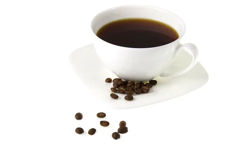 A cup of coffee with beans.