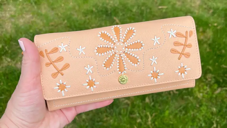 Close up of flapover wallet being held.