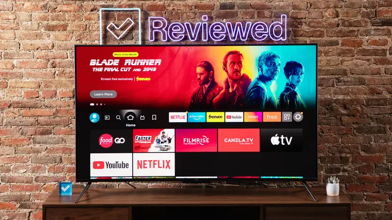 The Amazon Fire TV Omni on a wooden table displaying the Amazon Fire operating system.