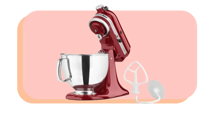 Red standing mixer with stainless steel mixing bowl next to two interchangeable attachment pieces.