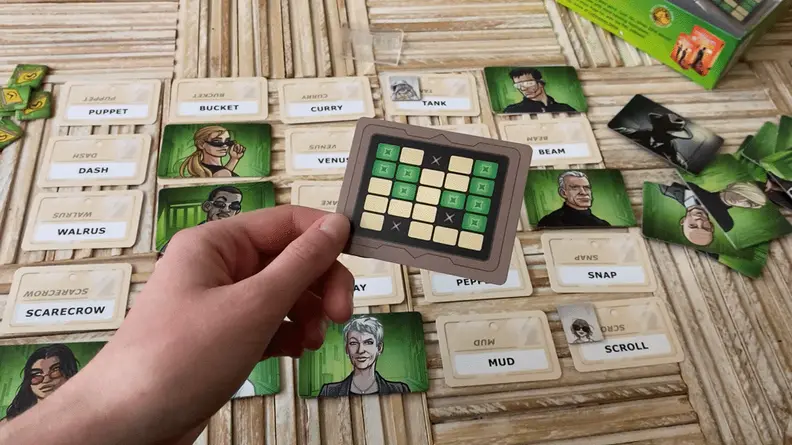 a hand flips the Codenames Duet legend card showing it's double sided