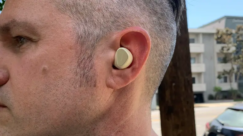 The profile of a man standing by a road while wearing the Jabra Elite 5 earbuds.