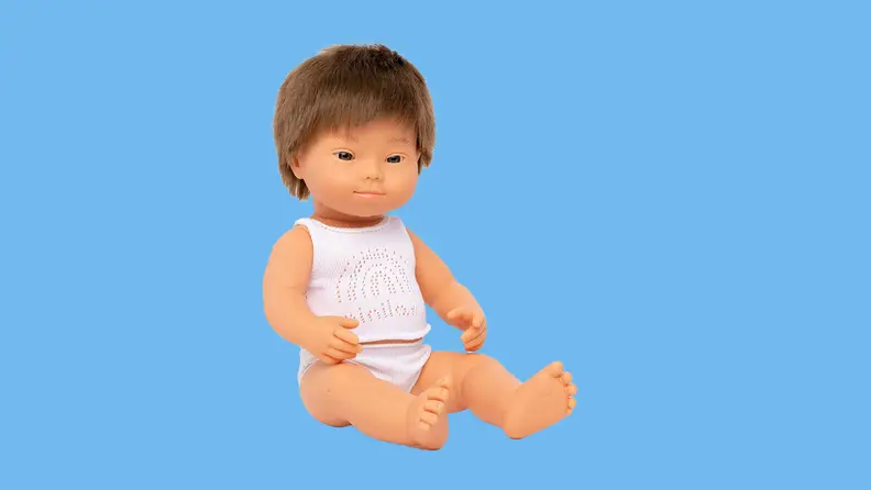 A Multi-ethnic Miniland boy doll product shot on a colorful background