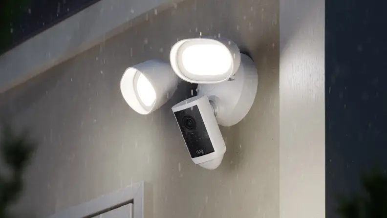 White and black ring camera with floodlights on outer wall