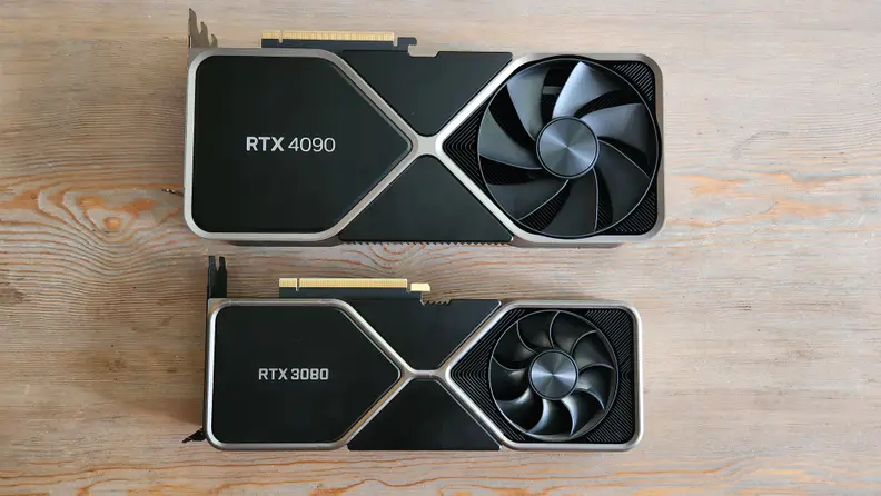 Two graphics cards lying flat on a wooden table side by side.