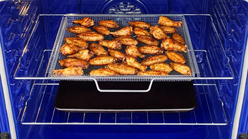 Some chicken wings being prepared inside the oven.