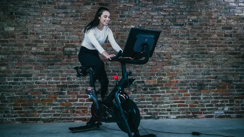 Woman riding Peloton Plus bike