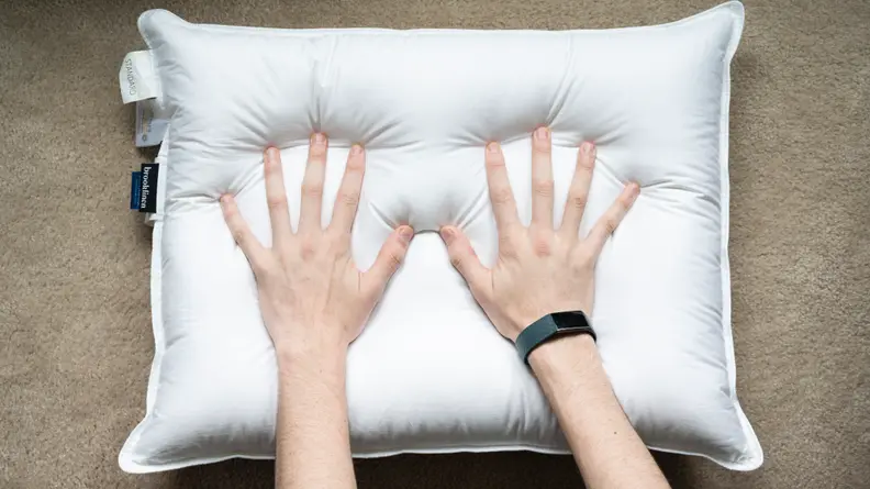 two hands pushing into Brooklinen pillow