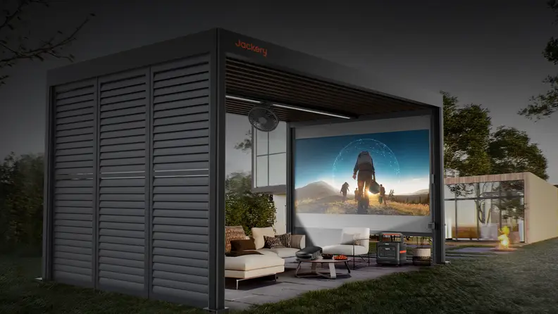 An outdoor pergola-style structure houses a large display screen, seating area, and portable power station in a landscaped backyard.