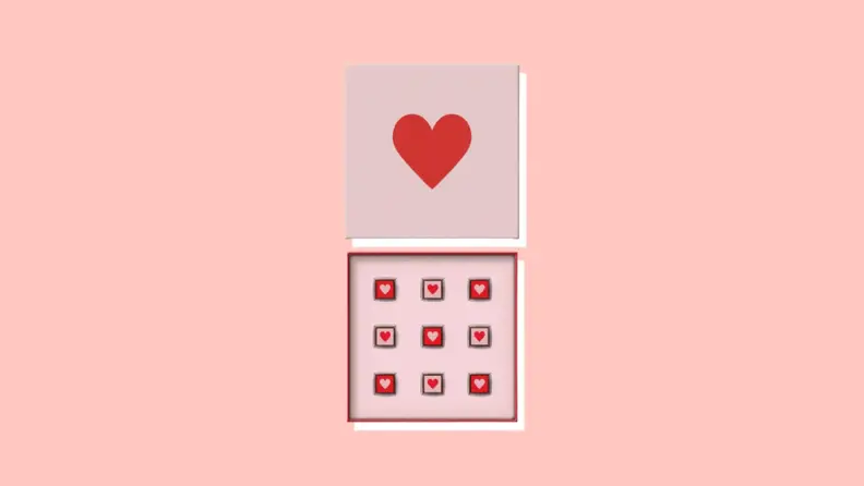 An open box of chocolates with a heart-shaped design.