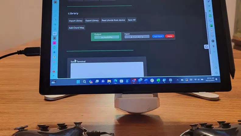 Photo of computer with Charachorder One in foreground. Computer screen shows the user has created the chord a+c+b+y to type "accessibility."