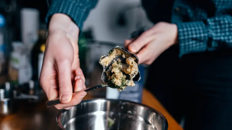 Scooping pesto with spoon