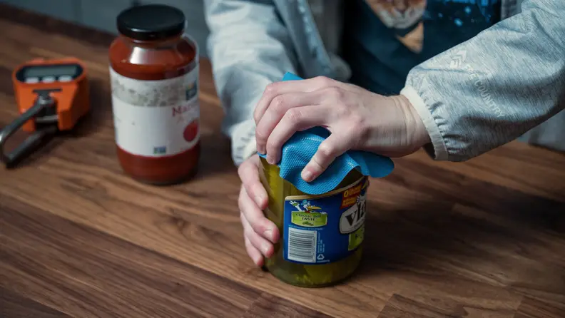 A tester demonstrates the Prepworks by Progressive Jar Grips on a jar of Vlasic dill pickles.