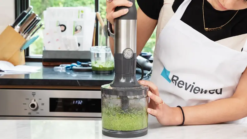 Person using the GE Immersion Blender to green blend homemade pesto sauce.