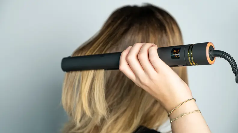 The author using the Hot Tools flat iron.