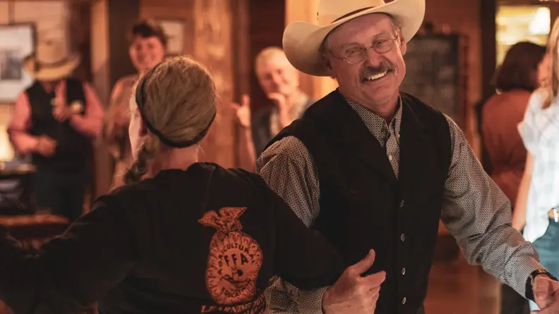 Two people dancing joyfully  in a rustic setting