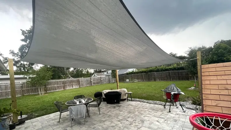 The image shows the shade sail installed over the patio.