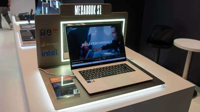 A Tecno Megabook S1 shown on a counter with a frame of a promo video on the displaying on its screen.