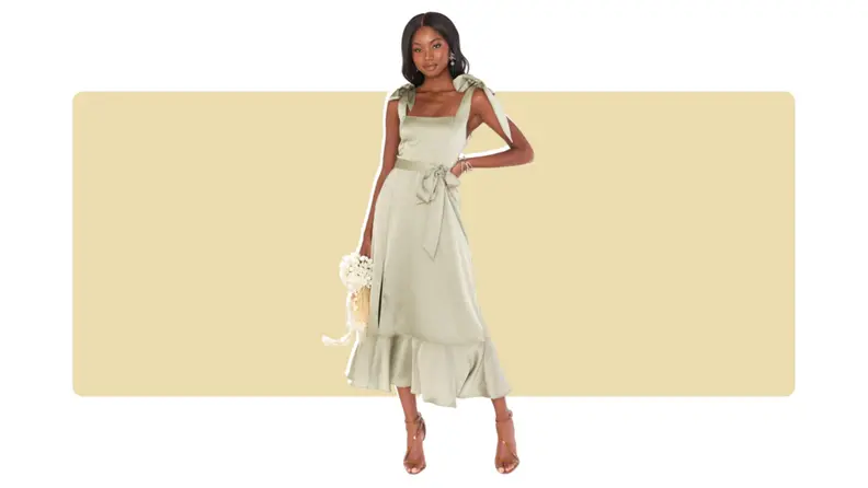 A satin green dress with bows along the waistband and shoulder straps.