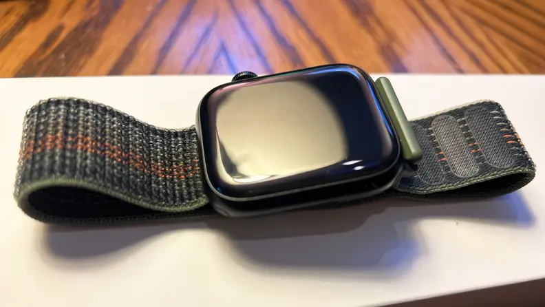 A midnight blue Apple Watch sits on a white box on a table top.