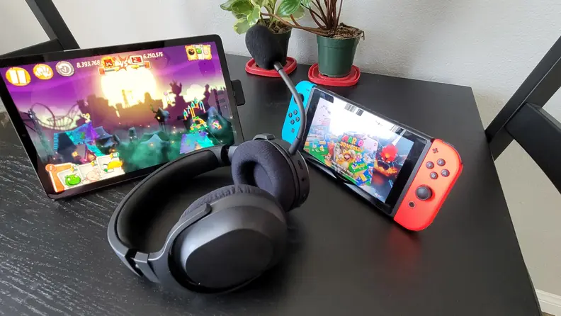 Razer Barracuda X sitting on a table in front of a tablet and a Nintendo Switch