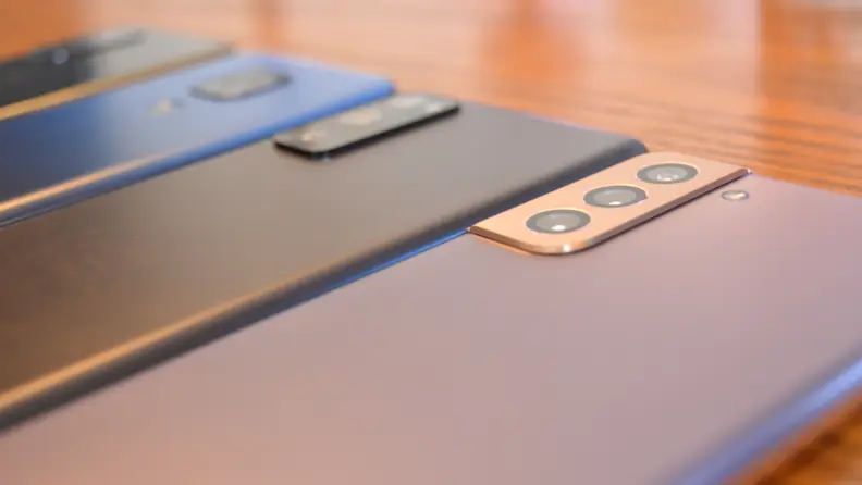 A row of android phones facedown in a brown table