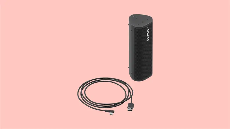 Front view of the Sonos Roam Bluetooth speaker set in black, alongside its USB charging cord.