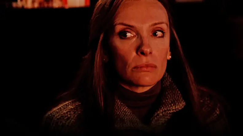 In a scene from Krampus (2015), Toni Colette is illuminated in natural light as the glares disconcertedly.