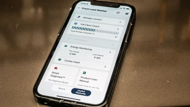 An Apple iPhone shows front-load washer controls on LG’s ThinQ app.