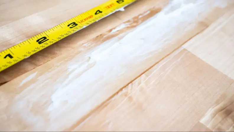 Butter smeared on a wooden countertop.