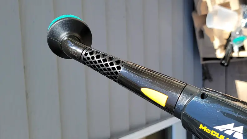 A black steamer attachment head on the steamer wand of a steam cleaner.