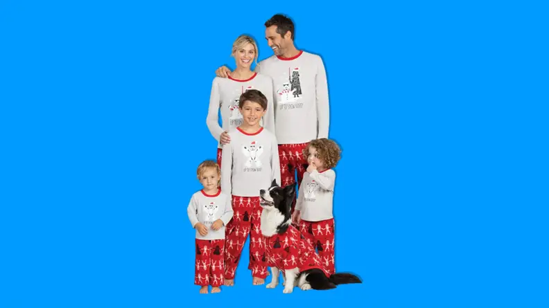 A family wearing PajamaGram Star Wars Christmas Pajamas on a blue background.