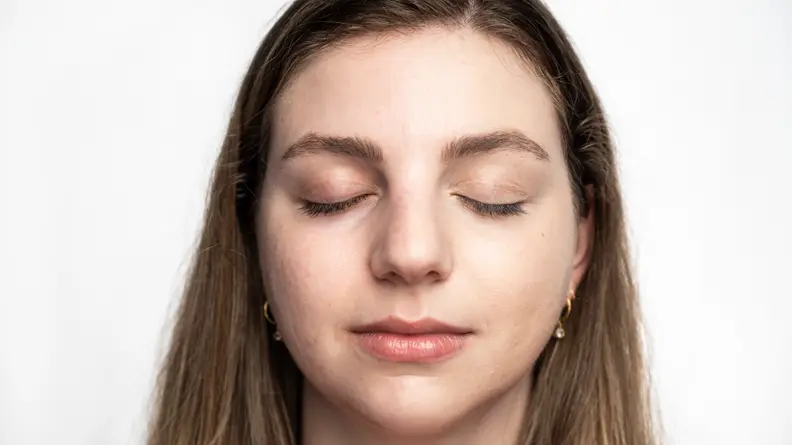 The author wearing the Tarte Shape Tape Concealer on the left side of her face.