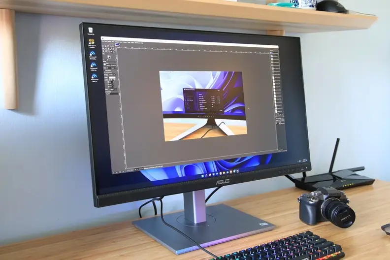 Asus VP28UQG computer monitor on wooden desk.