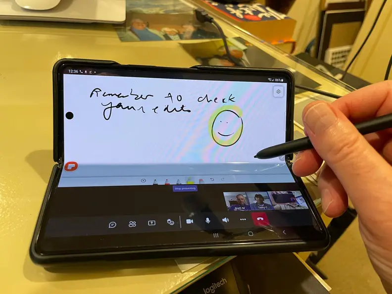 Person using stylus pen to write on screen of smartphone.