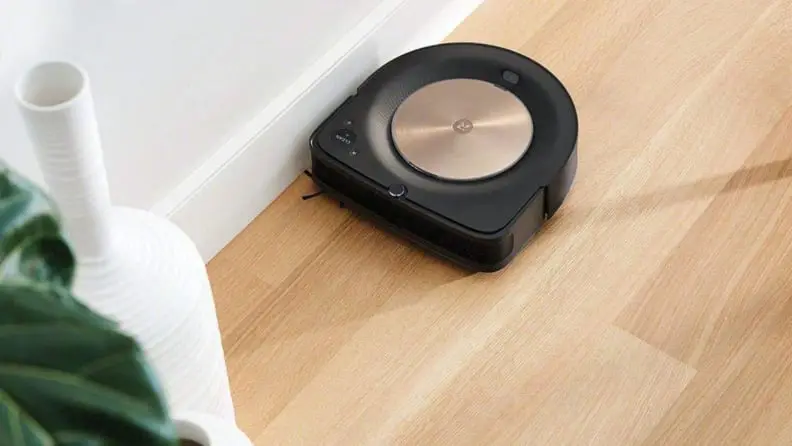 black/gold robot vacuum on wooden floors