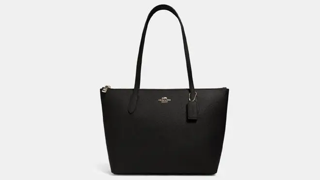 Black top handle purse in front of white background.