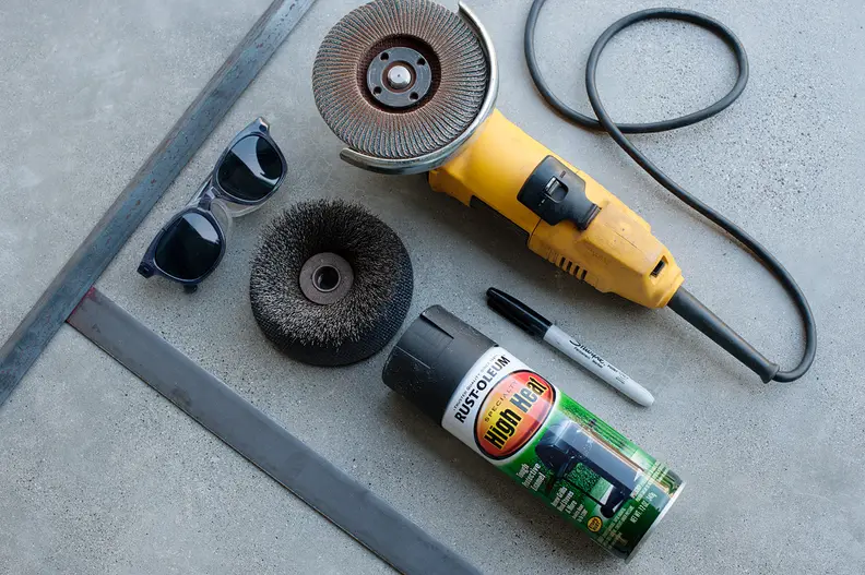 One washing machine drum, angle grinder, sanding disc, angle-stock and flat-stock steel, high heat black paint, and of course safety glasses.