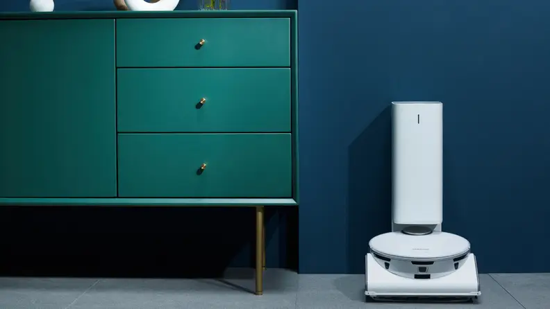 The Samsung Jet Bot A.I.+ in its dock next to a dresser