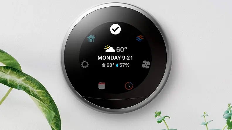 LED screen on circular smart thermostat mounted on wall.