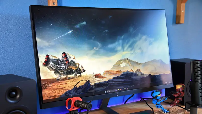 The Dark Matter 27-inch 165Hz IPS gaming monitor next to two speakers.