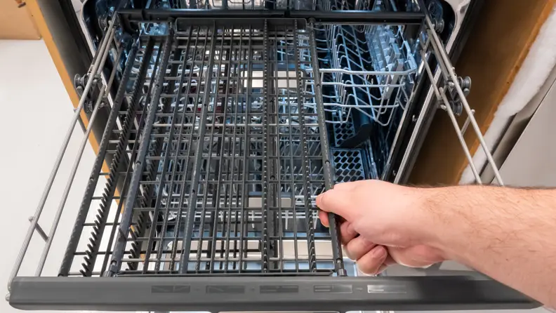 A close-up of a hand reaching into frame to slide the third rack's right half over to the left, opening up a lot of space for the rack underneath.