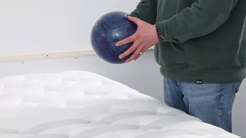 A person dropping a bowling ball on the Leesa Sapira Chill.