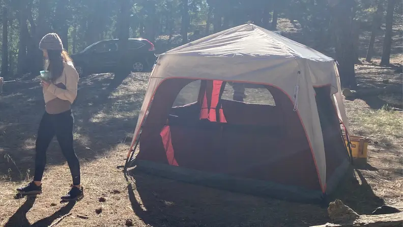 A woman walks away from a Coleman Instant tent