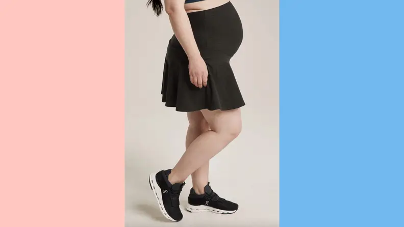 A pregnant woman wearing a sporty maternity skirt by BeyondYoga.