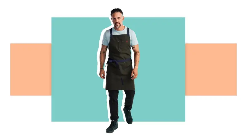 A man with an apron in front of a background.