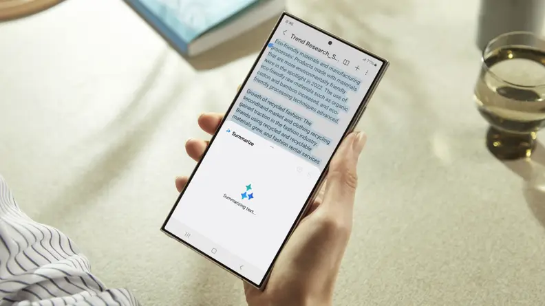 A person holds the Samsung S24 Ultra in their right hand. It is being used to transcribe audio.