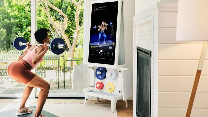 A woman squatting with the Tempo Studio workout mirror.