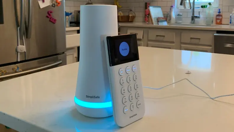 The SimpliSafe base station next to the SimpliSafe keypad on a kitchen counter.