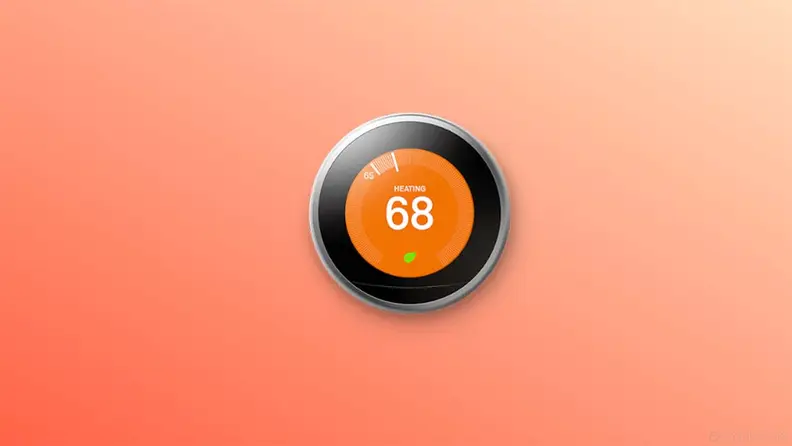 Google nest thermostat on orange background.